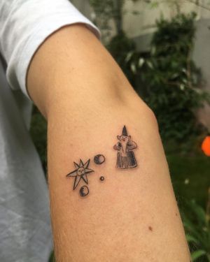 Elegant blackwork and fine line design featuring a wizard hat with moon and star elements, by Sofi. Perfect for arm placement.