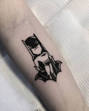 A bold blackwork Batman tattoo on the forearm, expertly done by artist Shasza. Show off your love for the caped crusader in style.