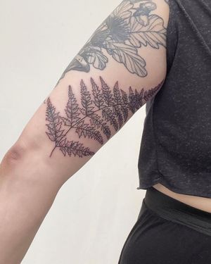 Elegant upper arm tattoo featuring a delicate tree, flowers, and leaves by Rachel Angharad. Perfect for nature lovers.