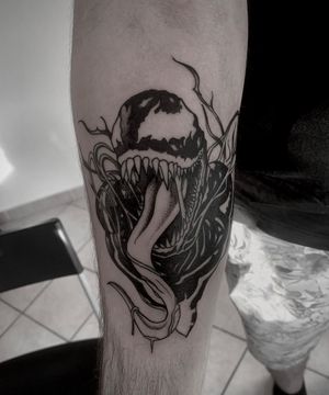 Unique blackwork tattoo on forearm featuring venomous snake design by Shasza.