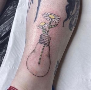 A stunning lower leg tattoo by Rachel Angharad featuring a beautiful illustrative design of a flower, bulb, and lamp.