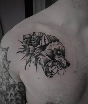 Illustrative design combining a fierce wolf and delicate flower, expertly inked by Shasza on the chest.