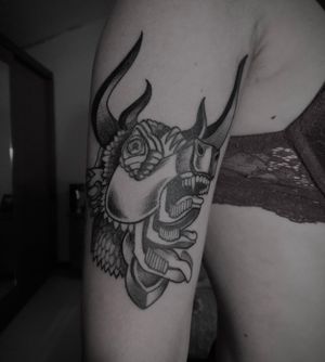 Get a striking illustrative blackwork bull tattoo on your upper arm by the talented artist Shasza. Show off your strength and determination with this powerful design.