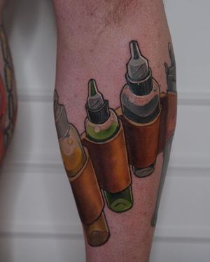 Vibrant new school tattoo on lower leg featuring a unique ink bottle design by Denis.