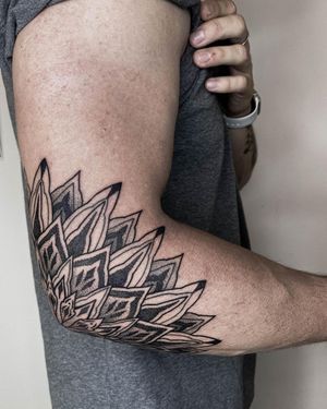 Bold blackwork mandala with ornamental and illustrative elements, by Nastya, perfectly placed on the elbow.