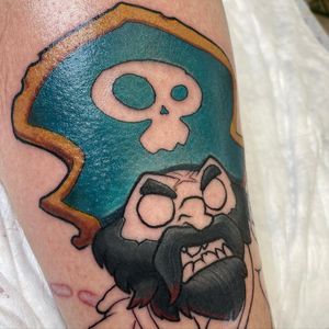Vibrant and detailed new school style tattoo of a pirate skull wearing a hat, expertly executed by artist Denis on the lower leg.