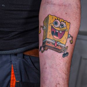 Get a fun and colorful new school SpongeBob tattoo on your forearm by talented artist Denis. A cool way to show off your love for this iconic character!