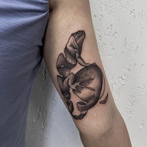 Embrace the beauty of nature with a whimsical design featuring a frog, fish, and fruit on your upper arm. Created by the talented artist Nastya.