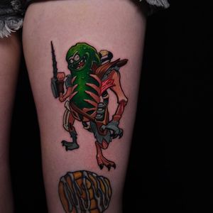 Vibrant new school tattoo on upper leg featuring a zombified Pickle Rick holding a gun surrounded by pickles and a skeleton, by Denis.