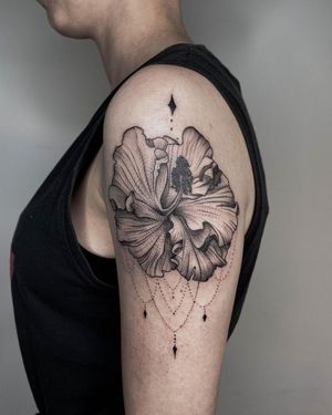 Elegant blackwork design of a flower on the upper arm, expertly executed by tattoo artist Nastya.