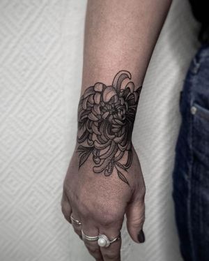 Elegant blackwork floral design by Nastya, perfect for your forearm. A timeless and beautiful tattoo choice.