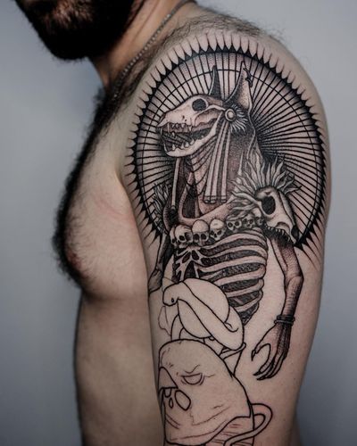 This bold upper arm tattoo features a dog, snake, skull, pattern, mandala, skeleton, and Anubis in a captivating illustrative style. By talented artist Nastya.