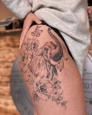 Liliia's blackwork and illustrative masterpiece on upper leg, featuring a majestic elephant and delicate flower design.