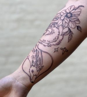 Unique blackwork tattoo by Liliia featuring a fierce dragon and delicate flower motif, beautifully illustrated on the forearm.
