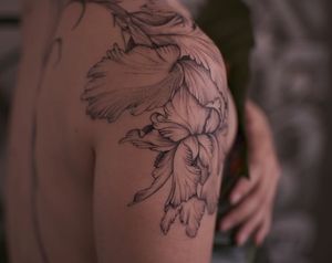 A stunning blackwork flower tattoo on the shoulder, by the talented artist Liliia. Unique and intricate design for a bold statement.