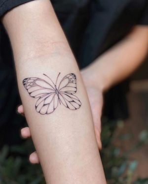 Elegant and intricate butterfly design by Liliia, combining blackwork and illustrative styles for a stunning forearm piece.