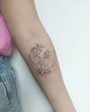 Exquisite fine line illustration of a moon, flower, and woman on the forearm by talented artist Maryna.
