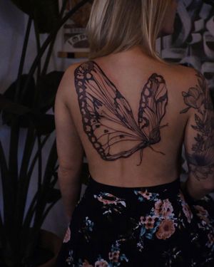 Capture the beauty of nature with this stunning blackwork butterfly tattoo by Liliia. Perfect for the back!