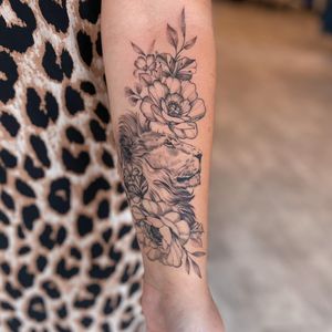 Bold blackwork lion and beautiful flower design by Liliia, perfect for showcasing on your forearm.