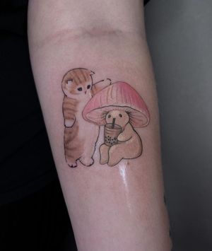 Get a unique illustrative tattoo on your forearm by artist Maryna featuring a playful cat, mushroom, and straw.