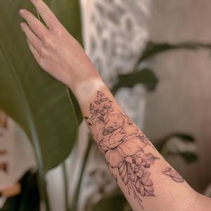 A stunning blackwork and fine line flower design on the forearm, intricately detailed by talented artist Liliia.