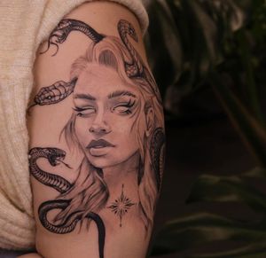 Detailed blackwork illustrative tattoo of a woman portraying Medusa with a snake on upper arm by Liliia. A unique and mesmerizing design.
