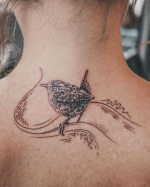 A captivating blackwork tattoo on the upper back featuring an illustrative bird surrounded by intricate patterns, done by artist George Francis.