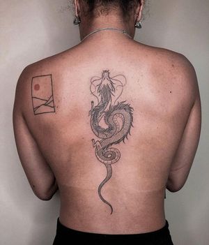 Get a stunning blackwork dragon tattoo on your back, designed by the talented artist Alisa Hotlib. Monochrome and intricate, this illustrative piece will make heads turn.