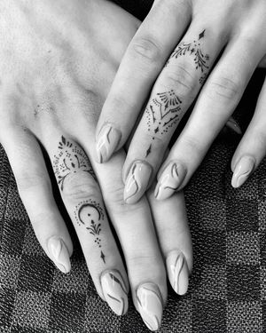 Delicate and intricate design by Angel Chavez featuring a moon, flower, and geometric pattern on the finger. Perfect for those who love fine line tattoos.