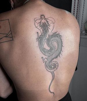 Experience the mystical power of a blackwork dragon tattoo on your upper back by artist Alisa Hotlib.