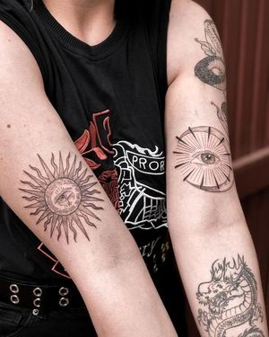 Unique blackwork tattoo featuring sun, moon, and eye motifs on your arm by Alisa Hotlib. Illustrative and intricate design.