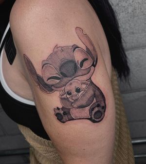Admire Angel Chavez's blackwork illustrative design featuring a cute baby Yoda with a stitch twist on the upper arm.