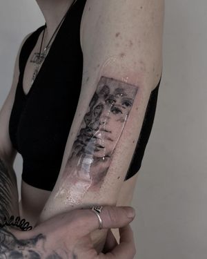 Impressive blackwork tattoo on upper arm, featuring a stunning and detailed portrait of a woman. By artist Toma.