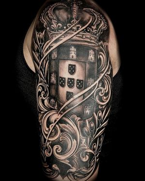 Elegant blackwork castle with intricate filigree crown on upper arm, by tattoo artist Mika.