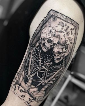 Unique blackwork tattoo on upper arm featuring skull, skeleton, coffin, and love motif by Ruslan.