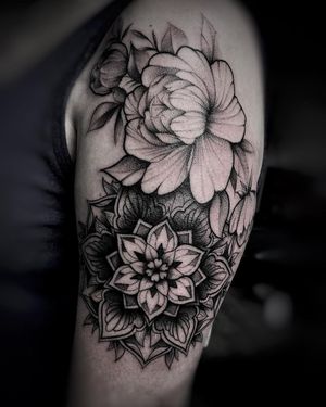 Elegant blackwork and illustrative design by Ruslan, combining intricate flower and mandala motifs on upper arm.