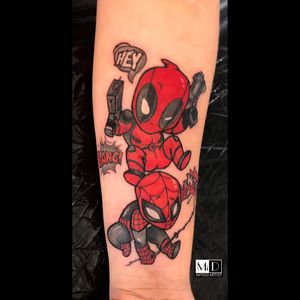 Colorful new school design featuring Spiderman, Deadpool, and a gun with a powerful quote, expertly inked by Mika on the forearm.