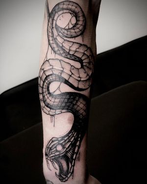 A stunning blackwork snake tattoo by Ruslan, beautifully designed to wrap elegantly around your lower leg.