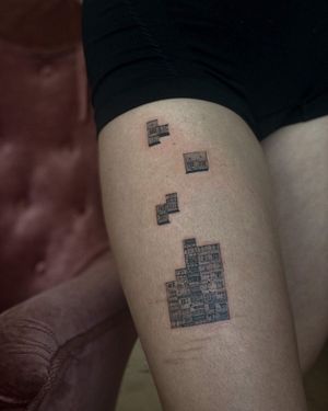 Unique blackwork tattoo combining Tetris blocks and a house, beautifully illustrated on the upper leg by Toma.