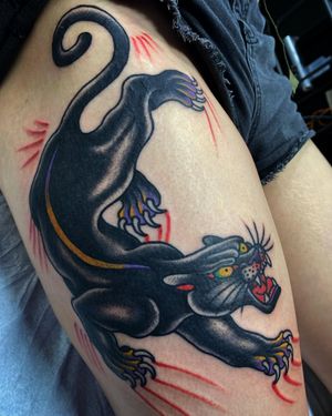 Illustrative and bold panther design on upper leg, expertly executed by tattoo artist Philip LaRocca.