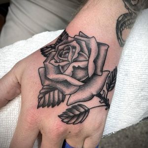 Beautiful black and gray flower tattoo by artist Sasha Ignarski, perfectly placed on the hand.