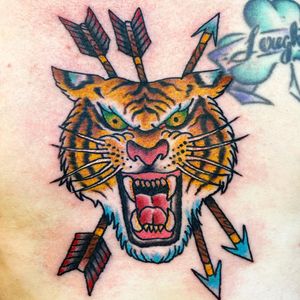 Impressive chest tattoo featuring a fierce tiger and arrow design, expertly done in a neo-traditional illustrative style by Jason Fancher.