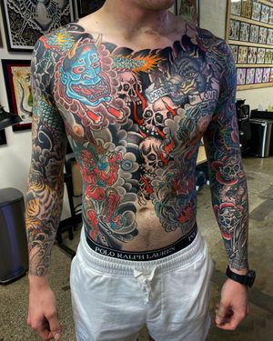 A bold blend of dragon, skull, hannya, and flower motifs with Japanese lettering, expertly executed on the chest by tattoo artist Philip LaRocca.