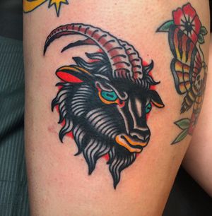Traditional style tattoo of a goat with prominent horns done by Nick Osbourn on the upper leg.