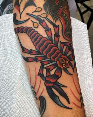 Get inked with a striking scorpion design by Philip LaRocca, combining illustrative and traditional styles for a bold statement on your lower leg.