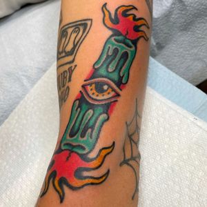 Unique arm tattoo by Nick Osbourn featuring a candle and eye in traditional illustrative style.