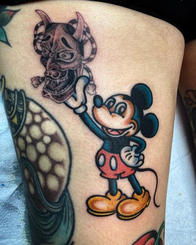 Illustrative tattoo by Philip LaRocca featuring a unique fusion of Mickey Mouse and Hannya mask motifs on the upper leg.