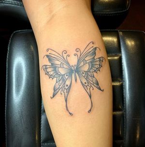 Unique blackwork tattoo by Kat Freedman featuring a beautiful butterfly design on the forearm.