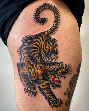 Get inked with a fierce and vibrant tiger design on your upper leg by the talented artist Philip LaRocca. Embrace the power of this majestic beast in a neo traditional style.
