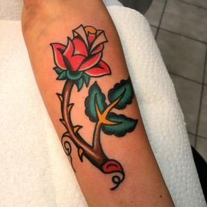 Get a timeless and colorful traditional flower tattoo on your forearm by the talented artist Nick Osbourn. Stand out with this classic design.